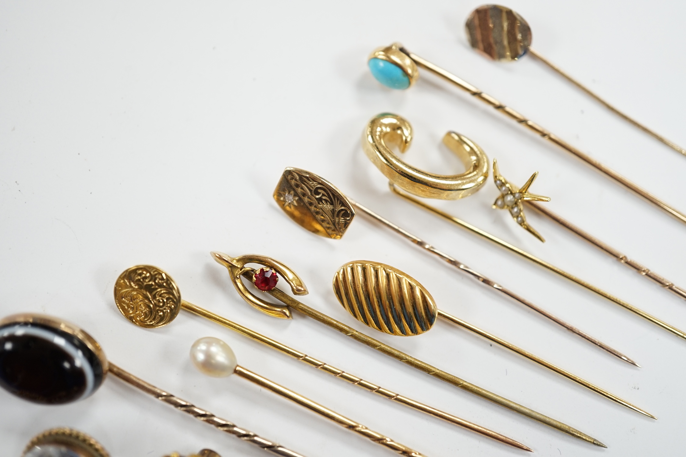 Fifteen assorted mainly early 20th century yellow metal and gem set stick pins, including diamond, seed pearl and banded agate, gross weight 23.1 grams.